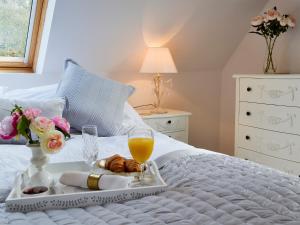 ein Tablett mit Essen und ein Glas Wein auf dem Bett in der Unterkunft Horncombe Stables in West Hoathley