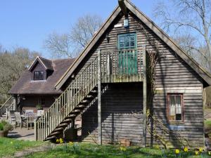 a wooden house with a staircase leading up to it at Horncombe Stables in West Hoathley