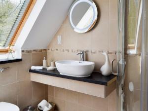 ein Bad mit einem Waschbecken und einem Spiegel in der Unterkunft Horncombe Stables in West Hoathley