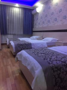 a hotel room with three beds in a room at burak otel in Unye
