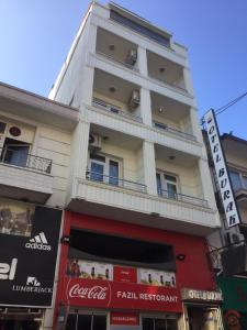 a tall white building with balconies on a street at burak otel in Unye