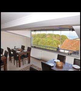 a dining room with tables and chairs and a large window at burak otel in Unye