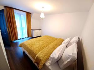 a bedroom with a bed with a yellow blanket at Conacul Munții Bucovinei in Câmpulung Moldovenesc