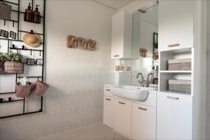 a white bathroom with a sink and a mirror at Villa Grace in Dalfsen