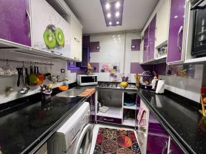 a purple and white kitchen with some food on the counter at Lovely 3 - Bedrooms apartment in Miami Bahary in Alexandria