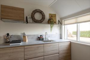 a kitchen with a sink and a window at Villa Grace in Dalfsen