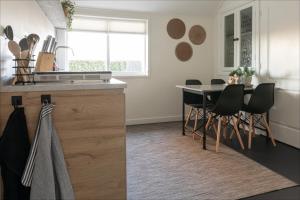 a kitchen with a counter and a table and chairs at Villa Grace in Dalfsen