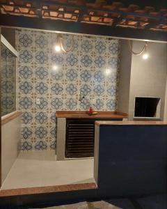 a kitchen with blue and white tiles on the wall at Casa 6 Suites e Eventos in Itaipuaçu