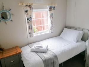 a small bedroom with a bed and a window at Salmon Leap Lodge in Dollar