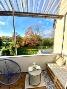 balcón con sofá, mesa y ventana en Wunderschöne Altbauwohnung mit Balkon - 102 qm, en Aachen