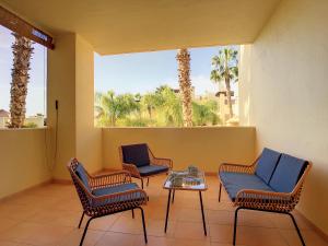 Habitación con 3 sillas, mesa y ventana en Roda Golf Resort - 8809, en San Javier