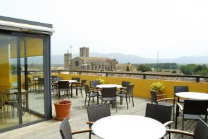 a patio with tables and chairs on a roof at Hotel Canet in Castelló d'Empúries