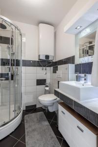 een badkamer met een toilet, een wastafel en een douche bij Sundowners Apartment, 52qm, double & single bed, 10 min from Old Town of Split in Split