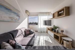 een woonkamer met een bank en een tv bij Sundowners Apartment, 52qm, double & single bed, 10 min from Old Town of Split in Split