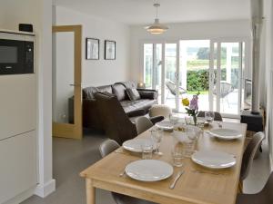 a dining room with a table and a living room at The Seashells in Brancaster