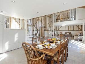 a kitchen and dining room with a wooden table and chairs at Tatters Barn in Bradwell