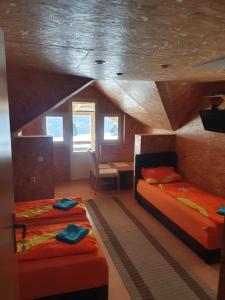 1 dormitorio con 2 camas, mesa y silla en Morehead Guesthouse Vlasic, en Vlašić