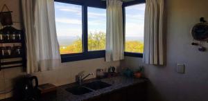 cocina con fregadero y 2 ventanas en Aldea de Montaña ,La Pichuca en Carpintería