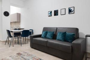 un divano nero con cuscini blu in soggiorno di Jòia Holiday Home a Crotone