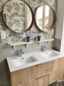 łazienka z 2 umywalkami i 2 lustrami w obiekcie Hostellerie Alsacienne w mieście Masevaux