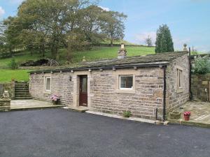 a small brick house with a driveway at The Dairy in Delph