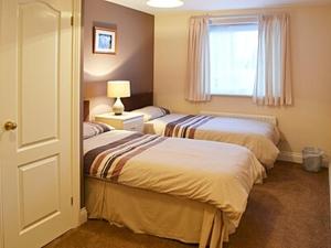 2 łóżka w pokoju hotelowym z oknem w obiekcie Willow Cottage w mieście Hadston