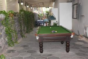 a pool table sitting in a courtyard with a pool at Sounds Suite for families in Migdal