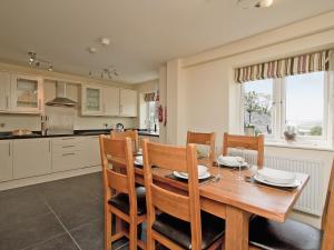 cocina y comedor con mesa de madera y sillas en Shoreline Penthouse - 27142, en Alnmouth