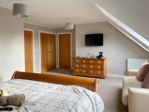 1 dormitorio con 1 cama y TV en la pared en Shoreline Penthouse - 27142, en Alnmouth