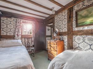 a bedroom with two beds and a dresser in it at Pen Copi in Trefeglwys