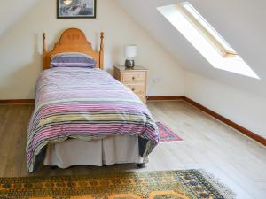 a bedroom with a bed and a dresser and a window at Piglet Cottage in Elsdon