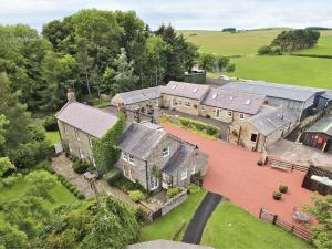 an aerial view of an old house with a yard at Piglet Cottage in Elsdon
