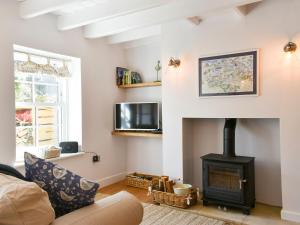 a living room with a fireplace and a couch at Esk Cottage in Egton