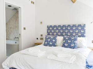 a bedroom with a white bed with towels on it at Esk Cottage in Egton