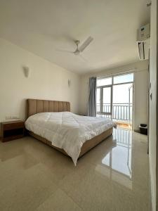 a bedroom with a large bed and a large window at Villa Vista With Swimming Pool in Lucknow