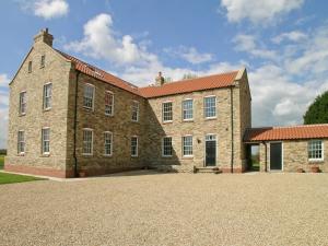 a large brick building with a red roof at Rascal Wood in Holme upon Spalding Moor