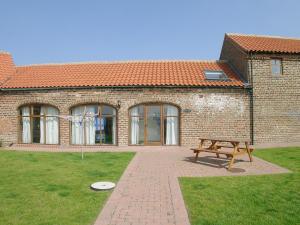 a brick building with a bench in front of it at Jenny Wren in Flamborough