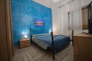 een blauwe slaapkamer met een bed met een blauwe muur bij Sa Matta de s'Oria in Giba