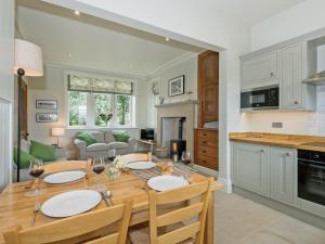 een keuken en een woonkamer met een tafel en stoelen bij The Gatehouse Beckfoot Hall in Great Musgrave