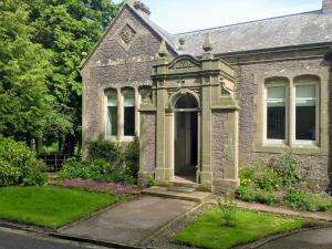 una vecchia casa in pietra con un giardino di fronte di The Gatehouse Beckfoot Hall a Great Musgrave