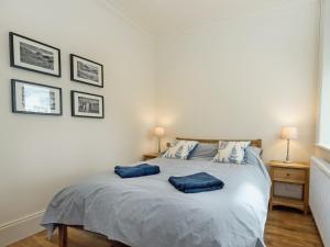 a bedroom with a bed with two blue pillows on it at The Gatehouse Beckfoot Hall in Great Musgrave