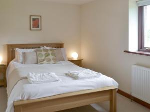 1 dormitorio con 1 cama con 2 toallas en Millers Rest, en Poundstock