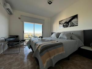 1 dormitorio con cama y ventana grande en Center Suites en La Plata