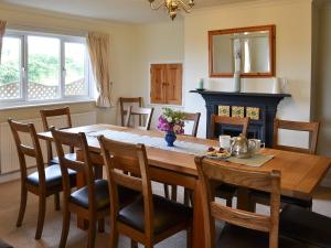 Barwick في Exbourne: غرفة طعام مع طاولة خشبية ومدفأة