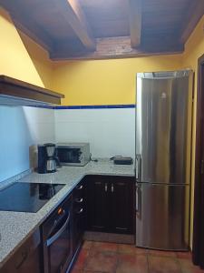 a kitchen with a stainless steel refrigerator at EL NIDO DE OLVIDO in Meiro