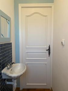 un baño con una puerta blanca junto a un lavabo en Foix Villa 150m2 dans très grand parc arboré en Foix
