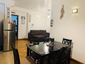 uma sala de estar com uma mesa e um frigorífico em City Apartment’s Nuwara Eliya em Nuwara Eliya