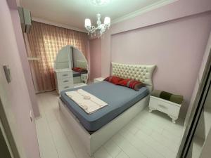 a small bedroom with a bed and a mirror at City center home in Karataş