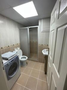 a bathroom with a washing machine and a toilet at City center home in Karataş