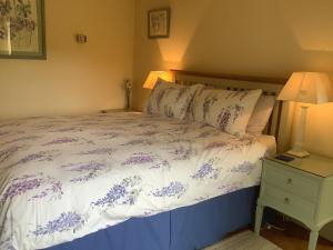 a bedroom with a bed with purple flowers on it at Wisteria Cottage in Skirpenbeck